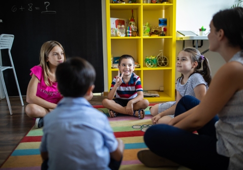 Kinderen zitten in een kring op de grond